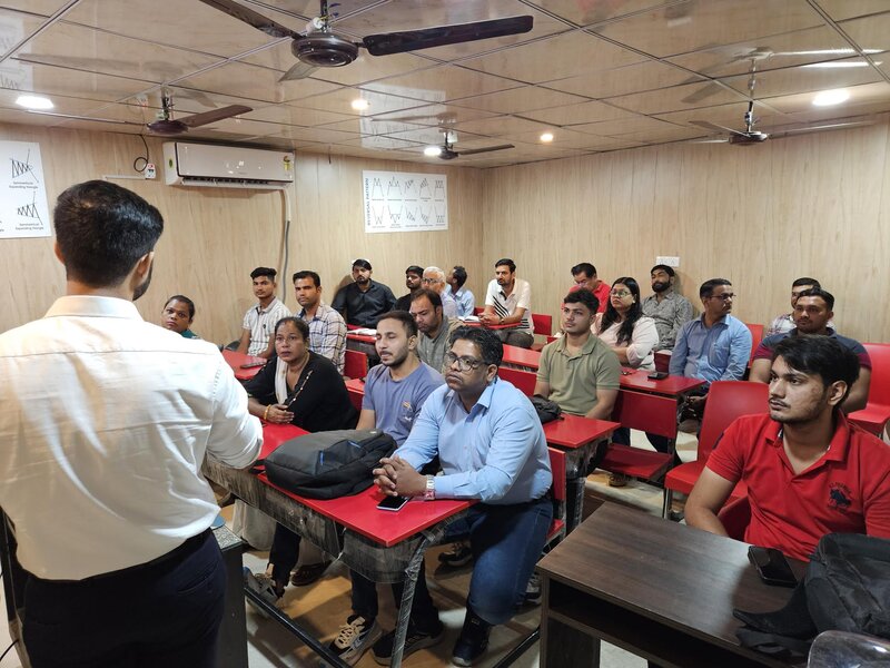 Mentor addressing a full classroom of trading students